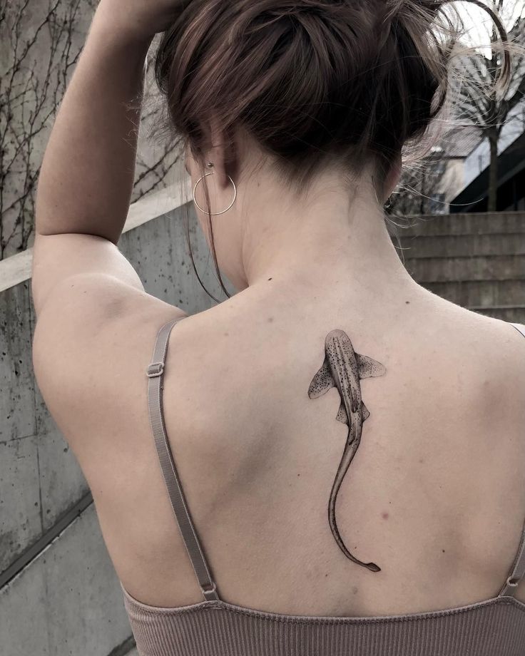 a woman with a lizard tattoo on her back