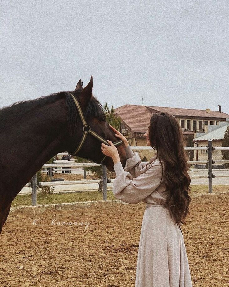 a woman in a dress petting a horse