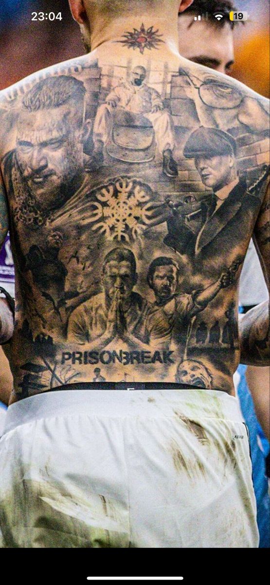 the back of a man with tattoos on his upper and lower part of his body