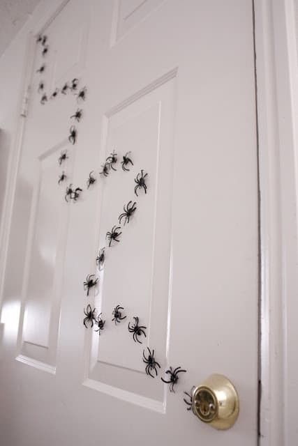 the door is decorated with black spider webs on it's side and says, tape plastic spiders to a door, this friday creepy especially if you are