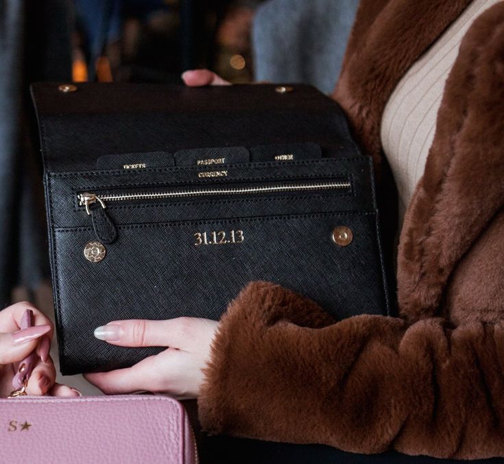 a woman is holding a pink purse in her hands