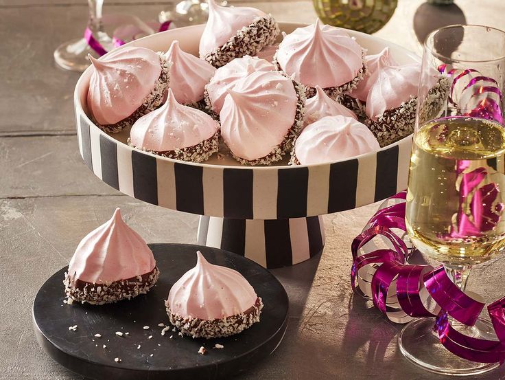 there are many desserts on the table with pink ribbons around them and wine glasses