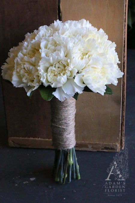 a bouquet of white carnations wrapped in twine and tied with jute