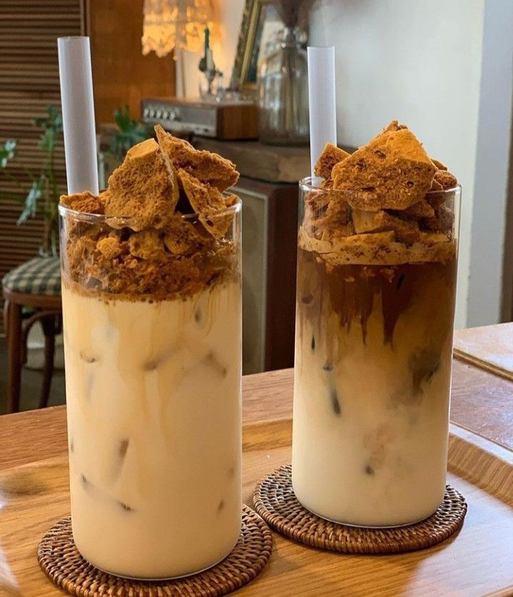 two glasses filled with food sitting on top of a table