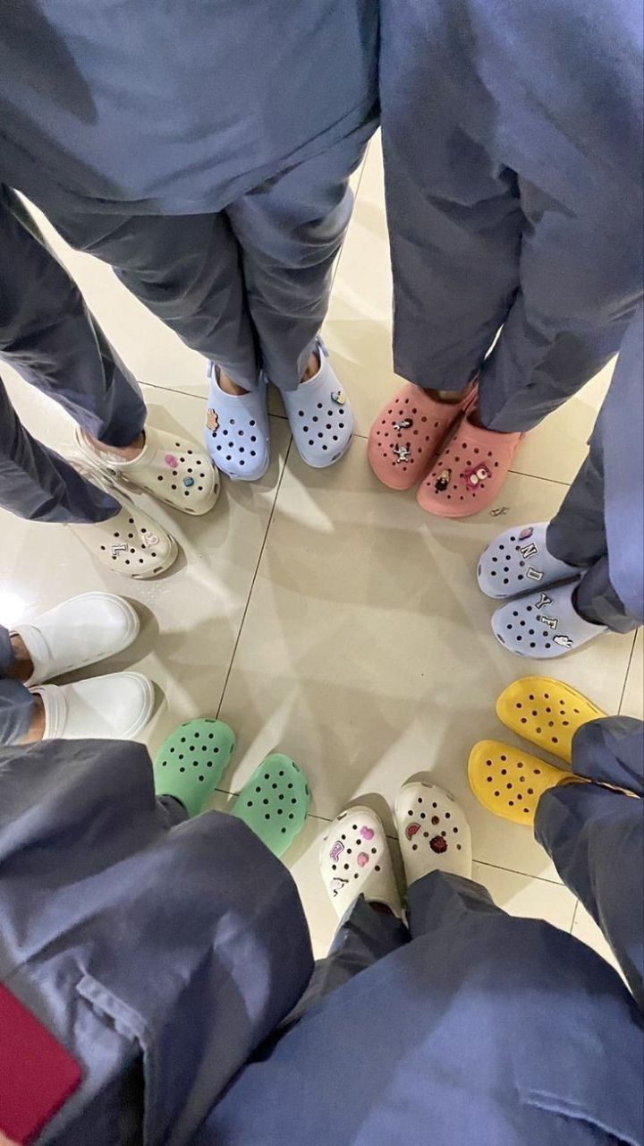 a group of people standing in a circle with their feet on the ground wearing crocs