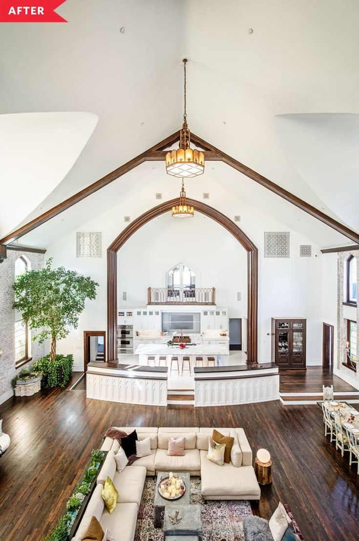 a large living room with wooden floors and white walls, an arched ceiling is the focal point for this open floor plan