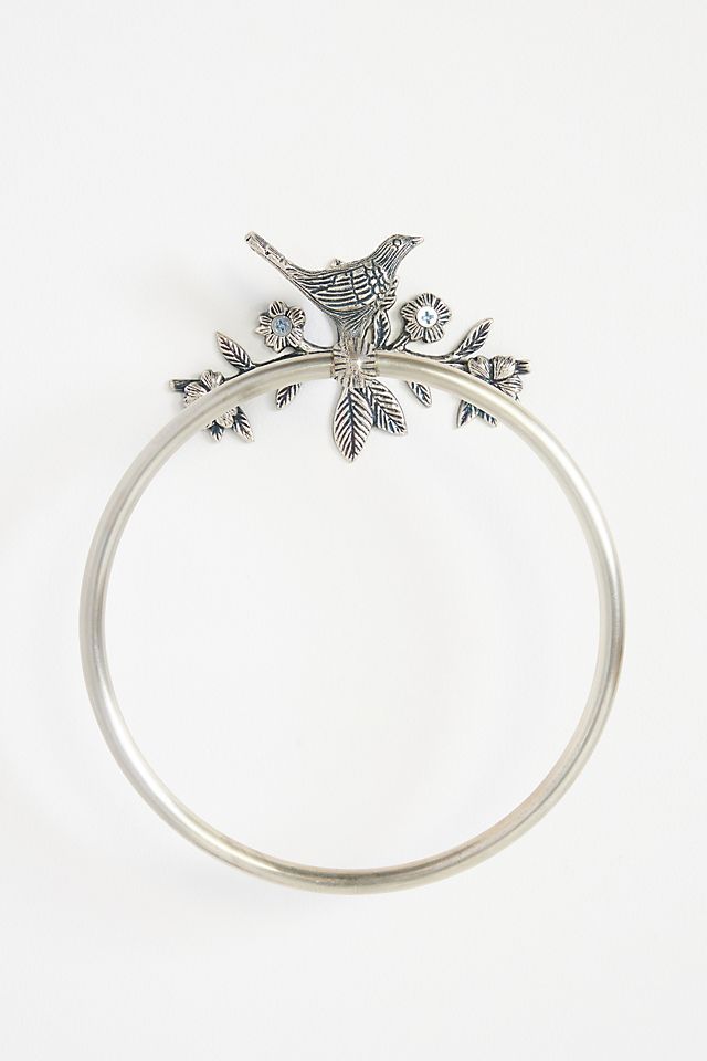 a silver bracelet with a bird on it