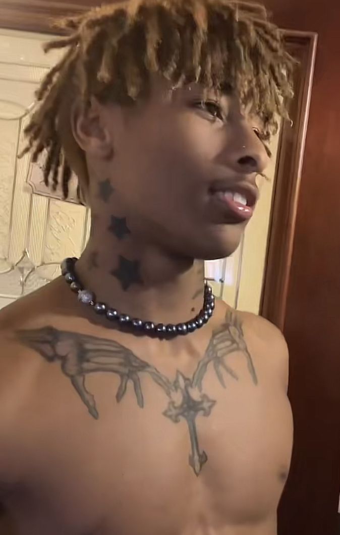 a young man with tattoos on his chest