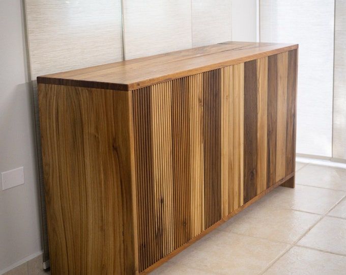 a wooden cabinet sitting on top of a tiled floor