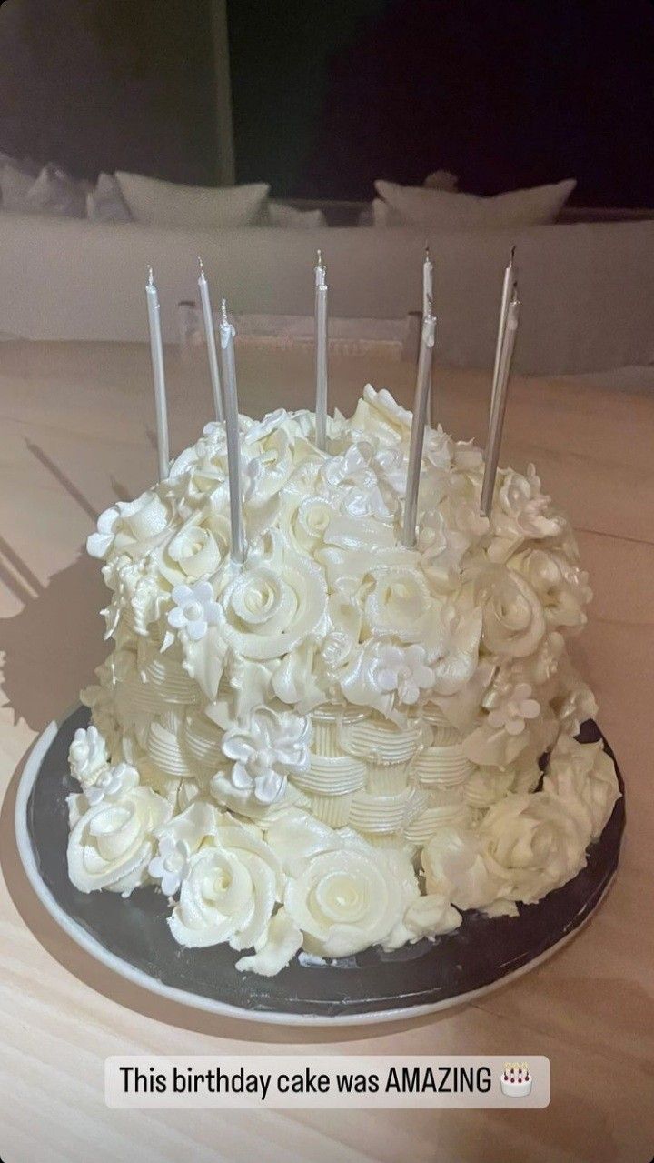 a cake with white flowers and candles on it