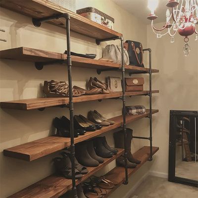 a room filled with lots of wooden shelves and shoes on top of each shelf in front of a chandelier