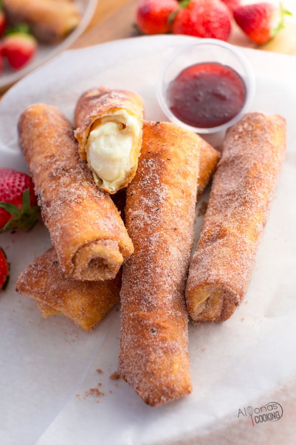 several pastries on a plate with strawberries and dipping sauces in the background