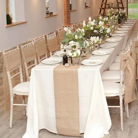 a long table is set with white flowers and place settings