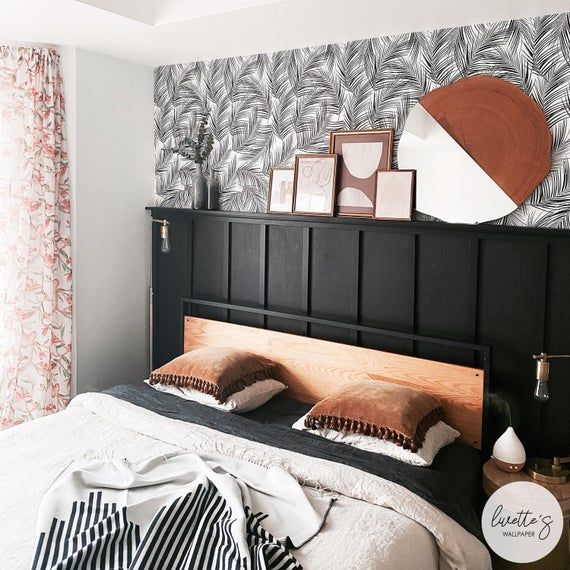 a bedroom with black and white wallpaper, wood headboard, striped bedding, and pink curtains