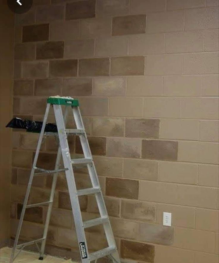 a ladder leaning against a brick wall in front of a light switch on the floor