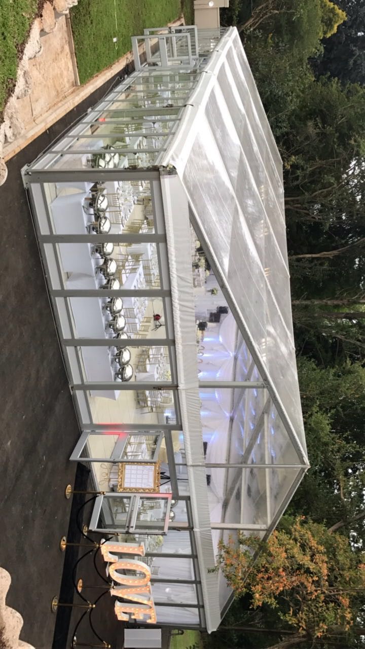 an aerial view of a glass house in the middle of a park with trees around it