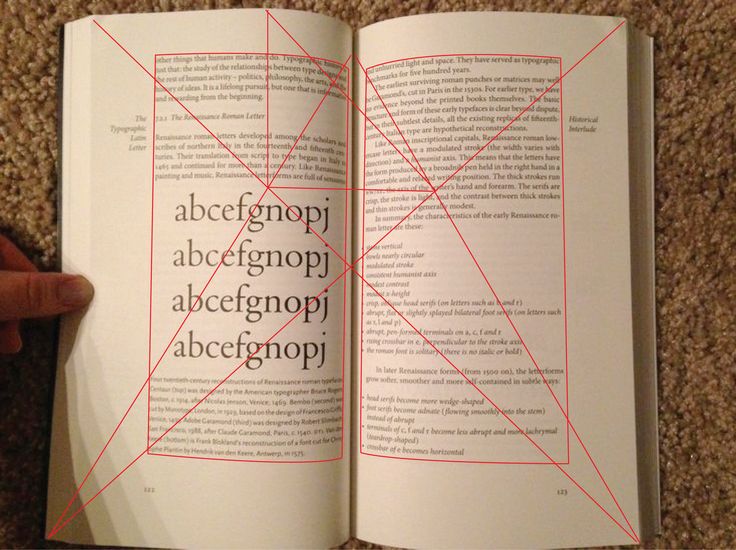 an open book with red lines on the page and hand holding it in front of it