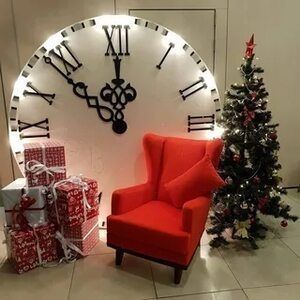 a red chair sitting in front of a large clock