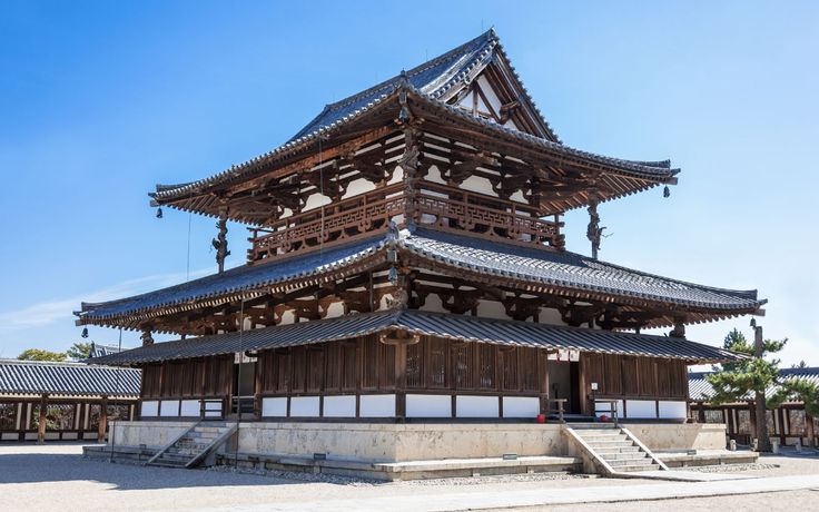 a tall wooden building sitting in the middle of a park