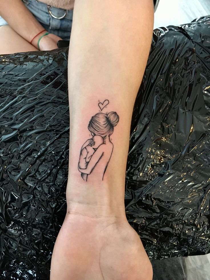 a woman's arm with a tattoo on it that has a girl holding a heart