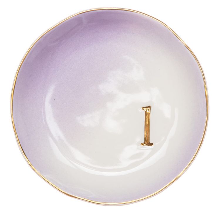 a purple and white plate with a gold letter i on it