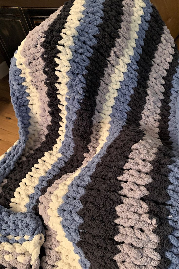 a crocheted blanket is laying on the floor