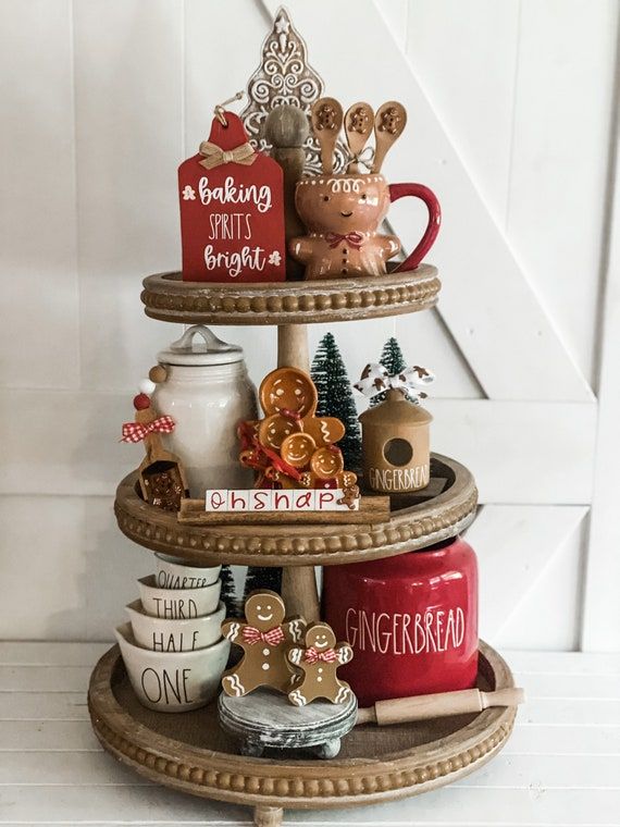 three tiered tray with christmas decorations and cookies on it's sides, along with other items