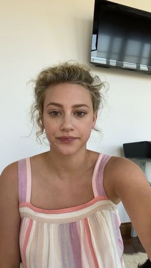 a woman in a pink and white top is posing for the camera