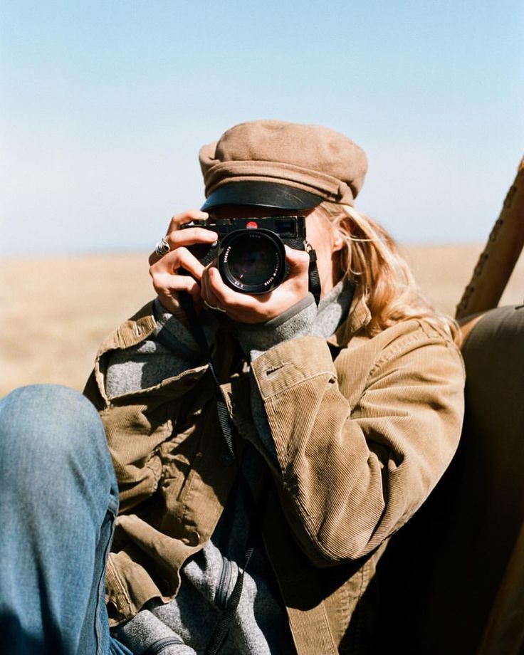 a man sitting in the back of a pick up truck taking a photo with his camera