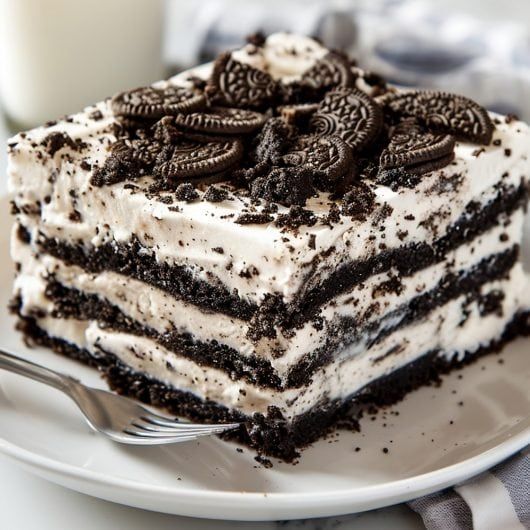 a close up of a piece of cake on a plate with a glass of milk