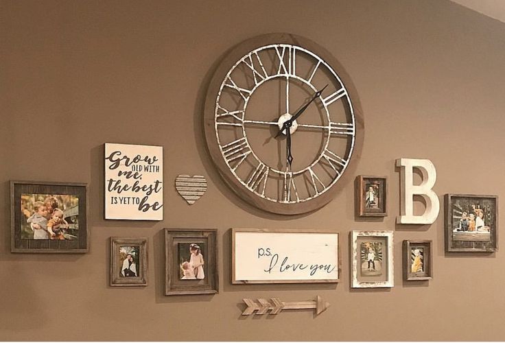 a large clock mounted to the side of a wall next to pictures and framed letters