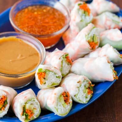 a blue plate topped with rolls and dipping sauce