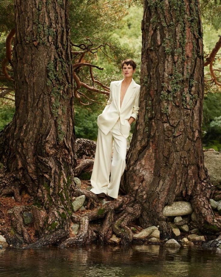 a woman standing in the middle of some trees