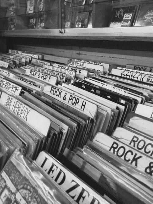 black and white photograph of records on shelves in a record store, with labels reading rock & pop