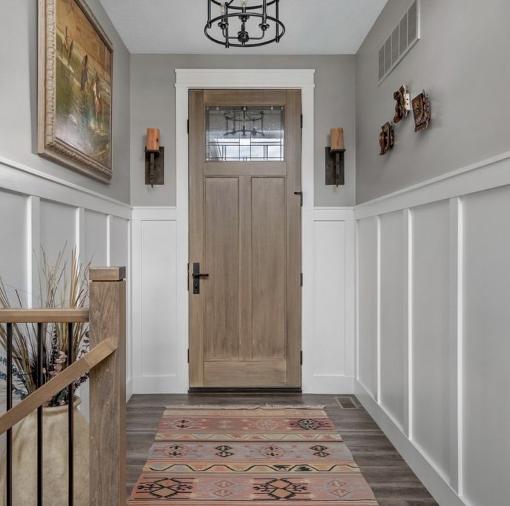 an entryway with a wooden door and rug on the floor