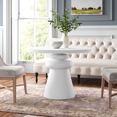 a living room scene with focus on the table and chairs, which are all white