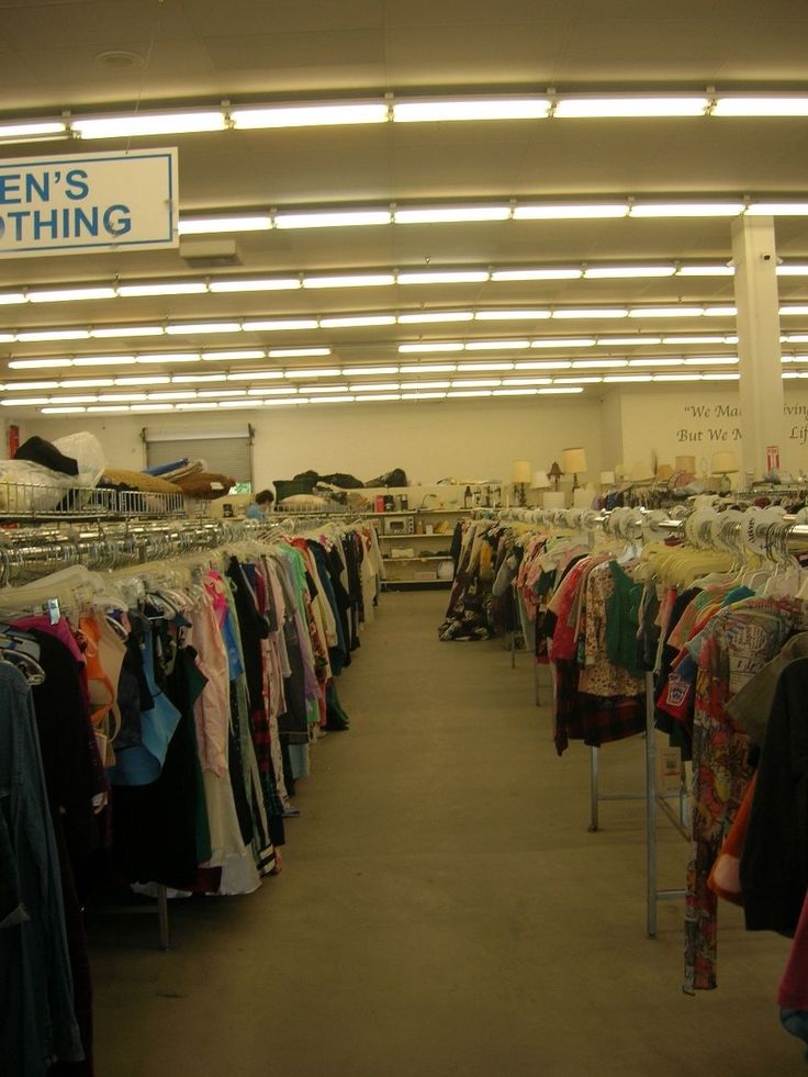 there is a clothing store with clothes on racks in the room and signs above it that say women's clothing