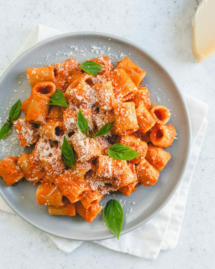 a plate of pasta with basil and parmesan cheese