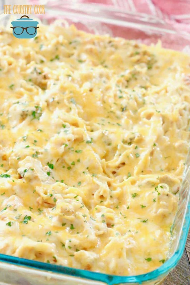 a casserole dish with chicken and cheese in a glass baking dish on a wooden table