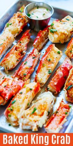 baked king crab skewers on a baking sheet with dipping sauce in the background