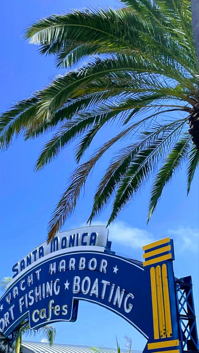 a blue and yellow sign that reads south monica yacht harbor, fishing boats and cafes