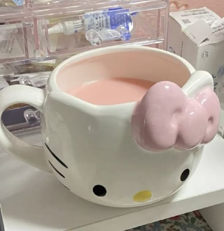 a hello kitty coffee cup with pink liquid in it