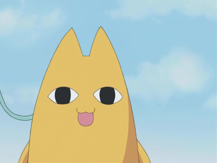 a yellow cat with its tongue out standing in front of a blue sky and clouds