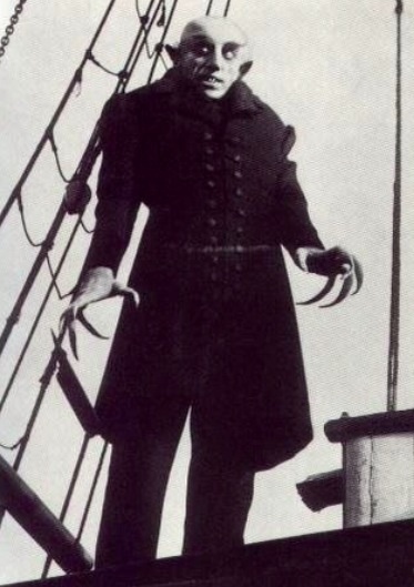 an old photo of a man standing on the deck of a ship with his hands in his pockets