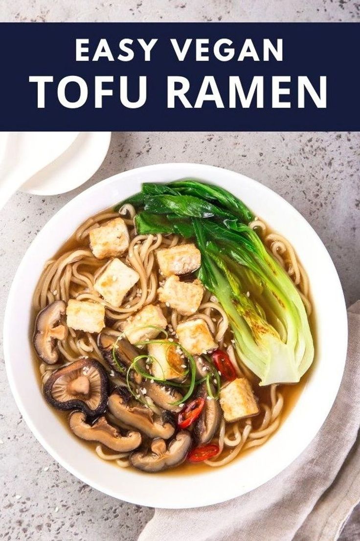 a bowl of vegan tofu ramen with noodles, mushrooms and green onions