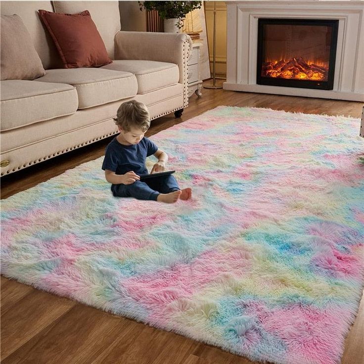 a child sitting on a shaggy rug in front of a fire place