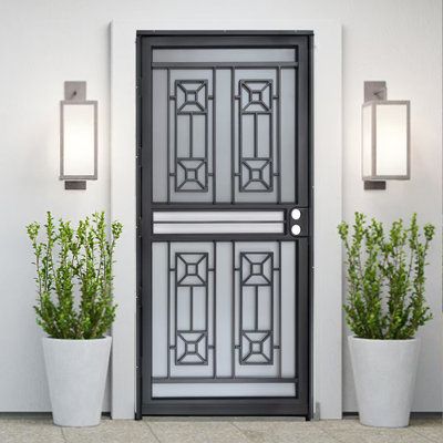 two potted plants sit in front of a door with decorative glass panels on it