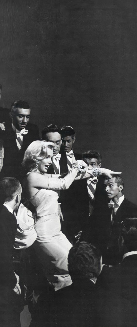 an old black and white photo of a woman in a wedding dress surrounded by other people