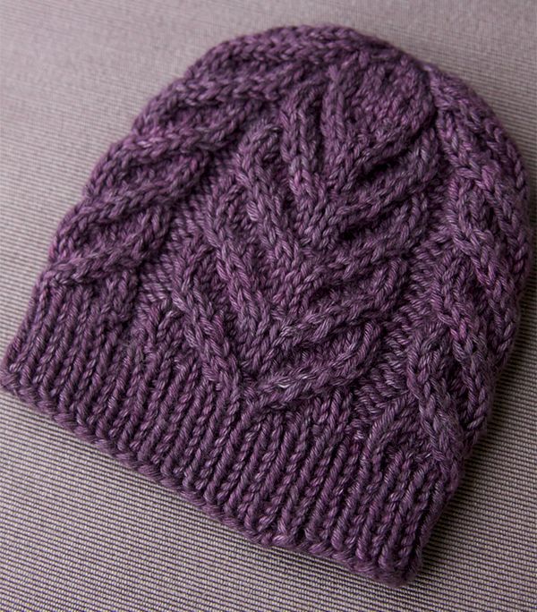 a purple knitted hat sitting on top of a couch