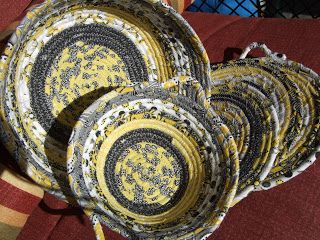 four yellow and black baskets sitting on top of a red blanket